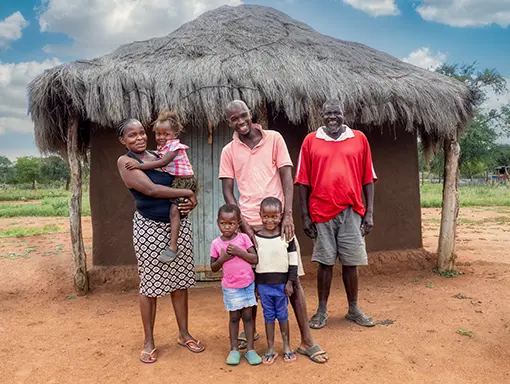 An image of an African family in front of their home